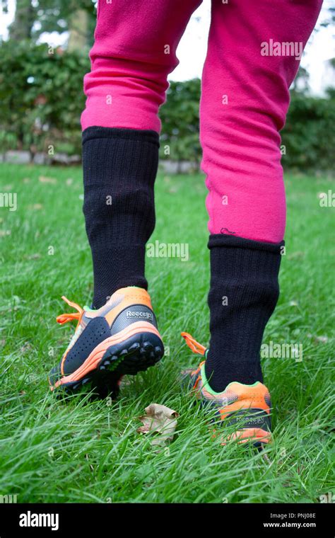 Girl Wearing Socks Over Trousers For Tick Bite Prevention To Protect