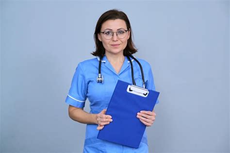 Premium Photo Portrait Of Mature Nurse Woman Holding Clipboard