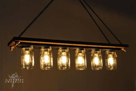 Mason Jar Chandelier Hanging From The Ceiling With Lights On It And