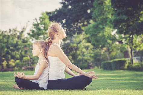 Madre E Hija Que Hacen Ejercicios De La Yoga En Hierba En El Parque