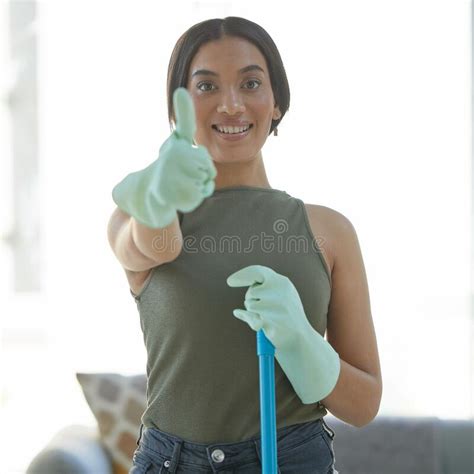 thumbs up portrait and happy woman maid cleaning the living room of a house for hygiene