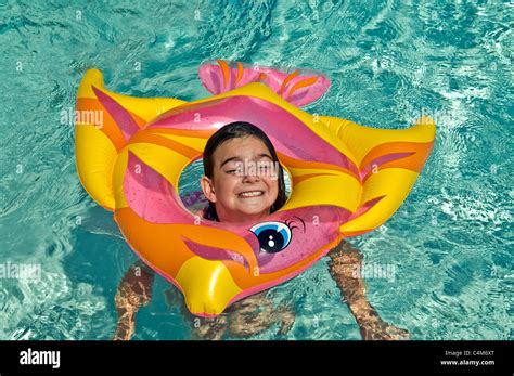 A Cute Girl Acting Silly With A Colorful Inner Tube In The Water Stock