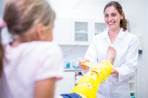 Doctor Putting Yellow Leg Brace On Girl Stock Image F0209442