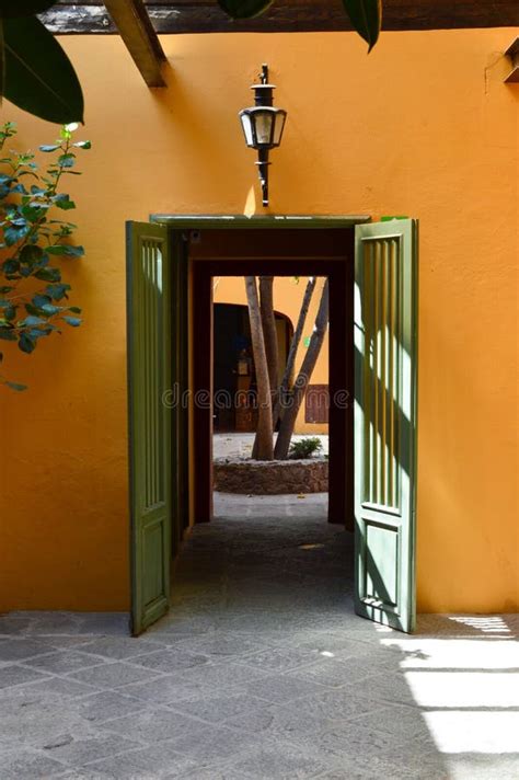 Old House Painted Orange With Wooden Door Painted In Green Stock