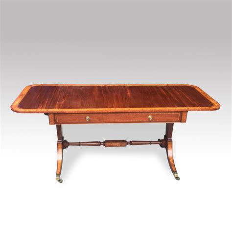 Regency mahogany sofa table, standing on brass claw castors with a reeded swept leg. Mahogany Sofa Table - Christopher Buck Antiques