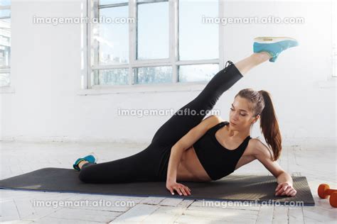 Beautiful Slim Brunette Doing Some Stretching Exercises In A Gym