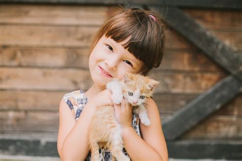 Cheerful Little Girl Holding A Cat In Her Arms Stock Photo Image Of