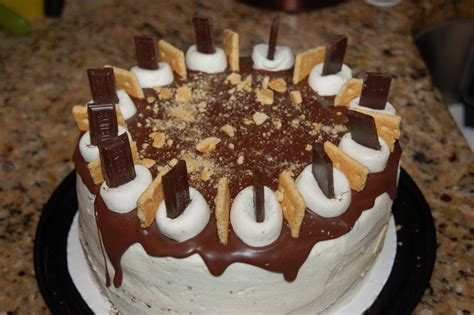 A Cake With Chocolate And White Frosting Is On A Black Plate In Front