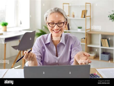 Friendly Senior Business Woman Consults With Her Clients Using Laptop