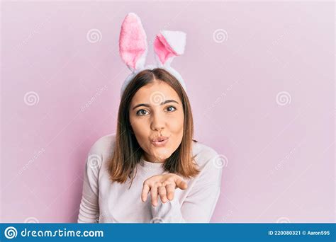 Young Beautiful Woman Wearing Cute Easter Bunny Ears Looking At The Camera Blowing A Kiss With