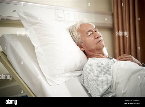 Asian Elderly Male Patient Lying In Bed Sleeping In Hospital Ward Or