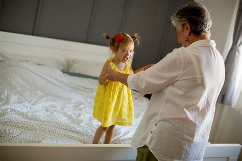 Oma Spielt Mit Einer Kleinen Enkelin Auf Dem Bett Premium Foto