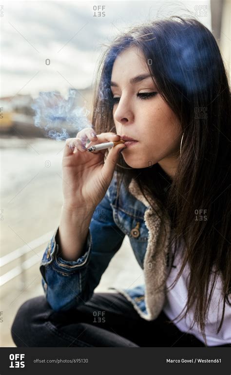 Young Woman Smoking A Cigarette Outdoors Stock Photo Offset