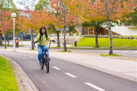 Joven Estudiante Asiática En Bicicleta Camino A La Universidad En Otoño