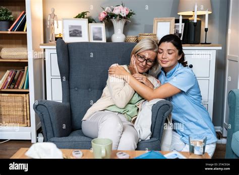 Caring Young Woman Nurse Help Old Granny During Homecare Medical Visit