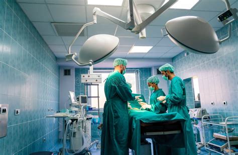 Group Of Surgeon Doctor Team At Work In Operating Room Stock Photo