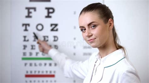 Female Optometrist Pointing At Eye Chart Vision Test In Ophthalmology
