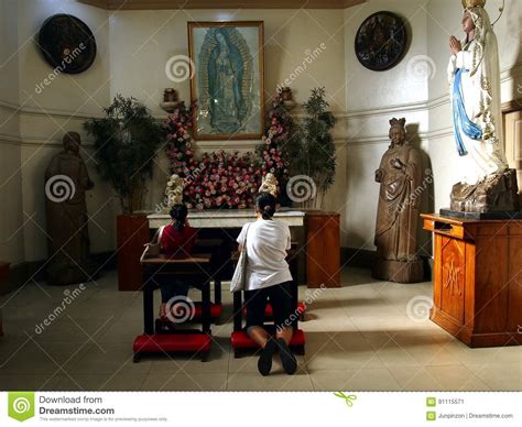 Catholic Devotees Pray To Religious Images Inside A Prayer Room At The