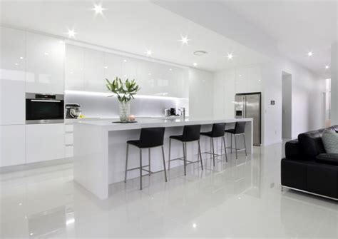 Modern gloss white base cabinets. White Modern Kitchen with island bench and stools, integral lighting, no handle cupboards, gloss ...