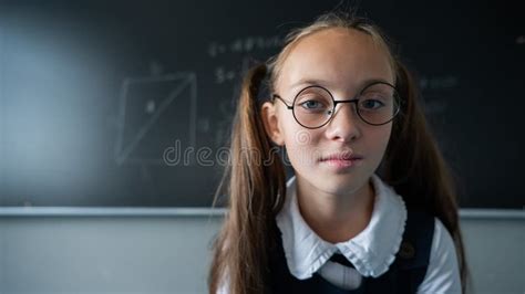 Portrait Of A Caucasian Girl In Glasses In The Classroom The Schoolgirl Answers At The