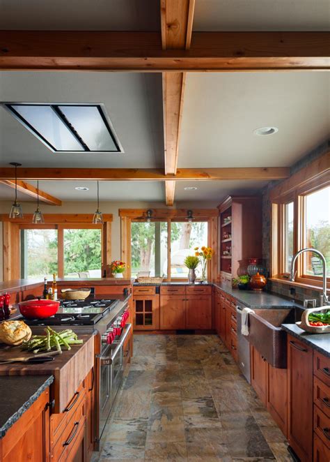Above the island are two unique, silver pendant lights situated behind an exposed wood header. Rustic Chef Kitchen With Butcher Block | HGTV