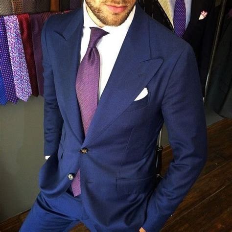 A Man In A Blue Suit And Purple Tie