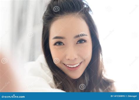 portrait de plan rapproché de la dame asiatique caucasienne inspirée se situant dans le lit