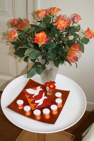Pinksteren of sinksen is een christelijke feestdag, waarmee de uitstorting van de heilige geest wordt herdacht. Pinksteren op een rond tafeltje. Met rood-oranje rozen ...