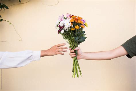 Man Giving A Woman A Bouquet Of Flowers By Stocksy Contributor Michela Ravasio Stocksy