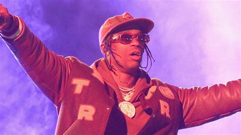 Travis Scott Is Wearing Brown Dress And Cap Gold Chains On Neck In Fog