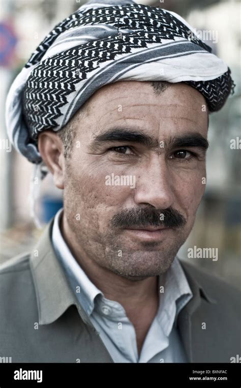 a portrait of a middle aged kurdish man wearing a headscarf from the town of shaqlawa in the