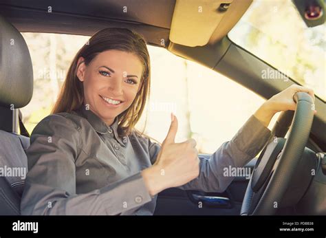 Happy Young Woman Sitting Inside Of Car And Showing Thumb Up Happy With