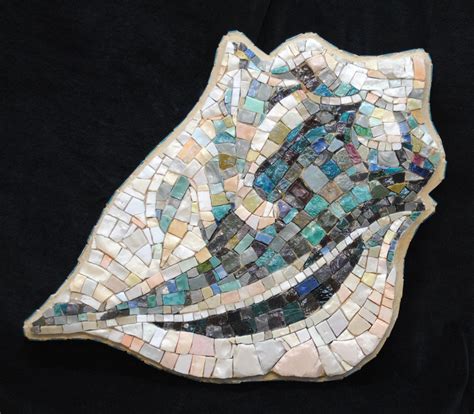 A Piece Of Art Made Out Of Glass And Mosaic Tiles On A Black Cloth