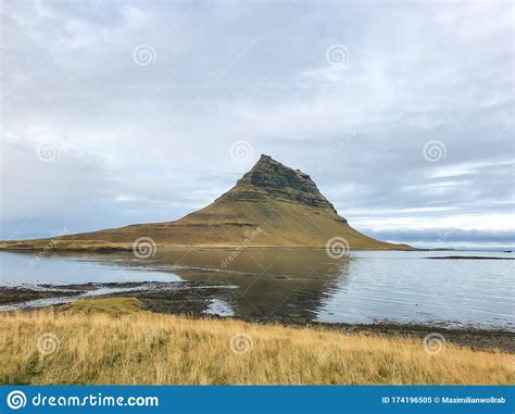 Kirkjufell In Iceland Famous Mountain Reflecting In Lake During Cloudy