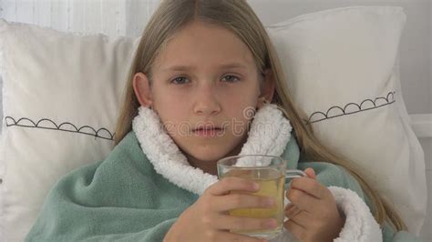 Sick Child Drinking Tea Ill Kid In Bed Suffering Girl Patient In