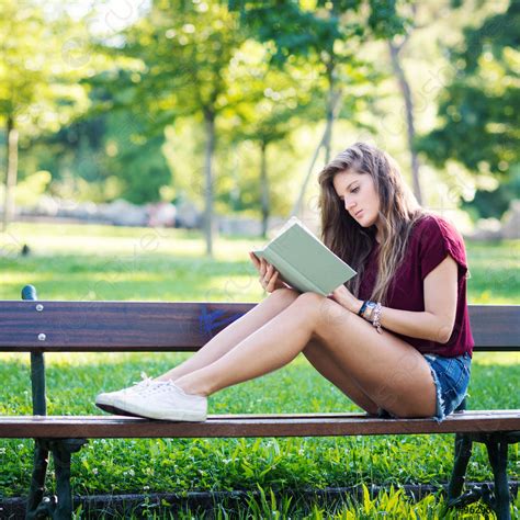 Young Woman Reading A Book Under A Tree In The Stock Photo 96290