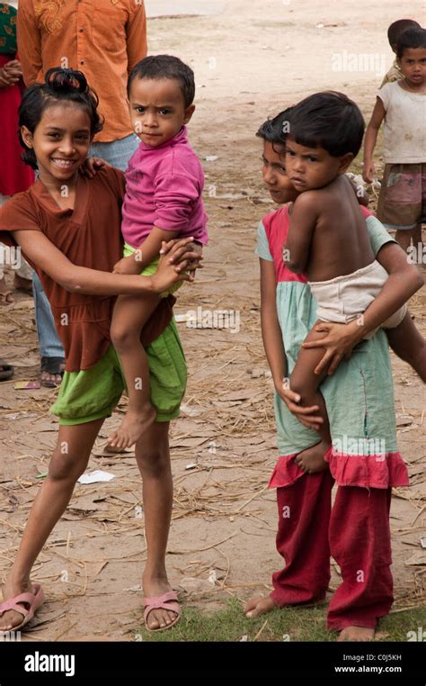 Une jeune fille du Bangladesh tient son jeune frère dans ses bras Photo Stock Alamy
