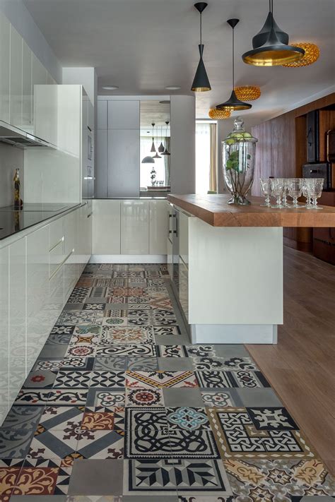 An edgy look that feels utterly doable is to place tile only in the cooking area and have it meld into another type of flooring—here, it's wood—for a striking contrasting look. 18 Beautiful Examples of Kitchen Floor Tile