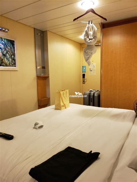 Two twin beds that convert to a royal king, measuring 72.5 inches wide by 82 inches long, boardwalk view balcony, sitting area, and a private bathroom. Allure of the Seas Spacious Balcony Category