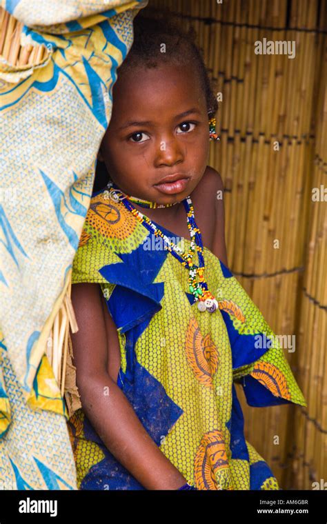 A Young Fulani Girl Stands Just Inside The Door Of Her Mud Hut In The