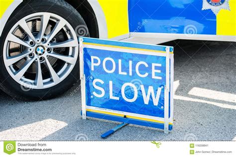 Large Police Slow Sign On The Road Beside A Patrol Vehicle Editorial Image