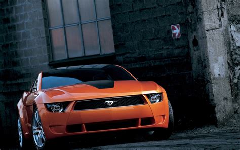 Orange Ford Mustang Parked Near Bricked Building Hd Wallpaper