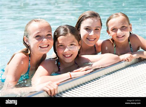 Group Of Girls On The Edge Of A Public Swimming Pool Stock Photo