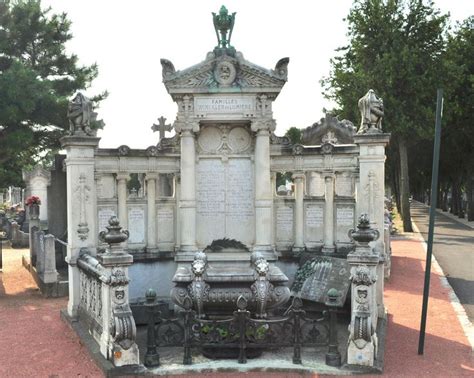 A Monument In The Middle Of A Cemetery With Statues Around It And Trees