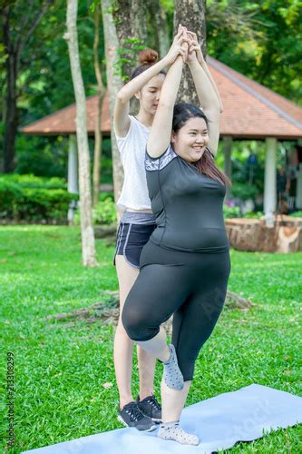 Asian Thin And Overweight Woman Doing The Tree Yoga Pose Together In