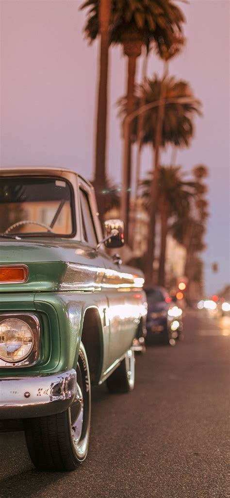 Vintage Car Parked On Ocean Blvd During Sunset Iphone 12 Wallpapers