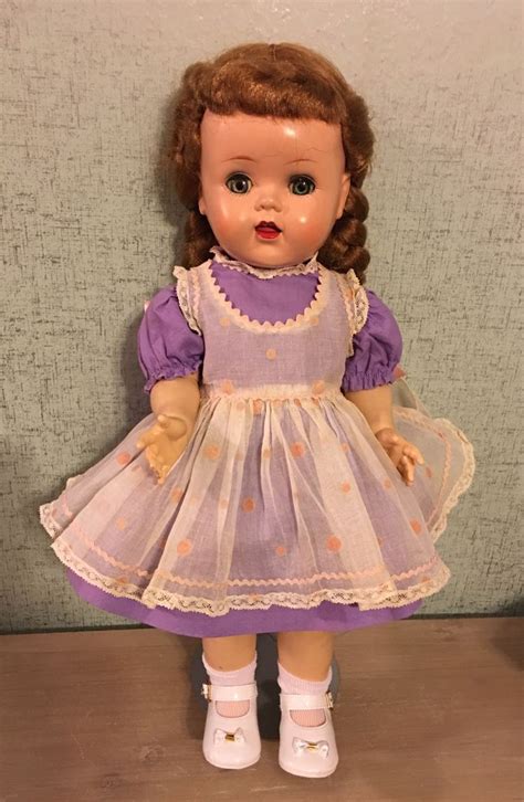 The Doll Is Wearing A Purple Dress And White Shoes