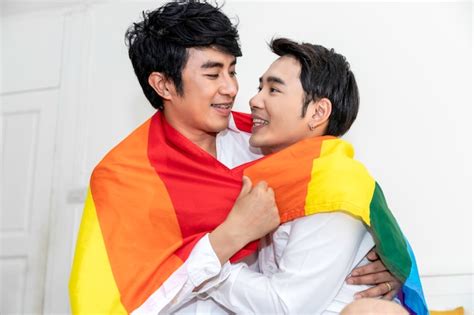 Premium Photo Portrait Of Asian Homosexual Couple Hug And Holding Hand With Pride Flag In Bedroom
