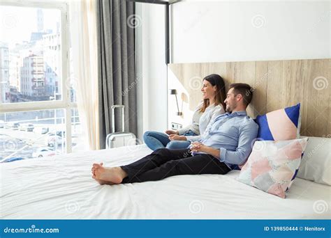 Beautiful Lovely Young Couple Lying And Relaxing On Bed Looking