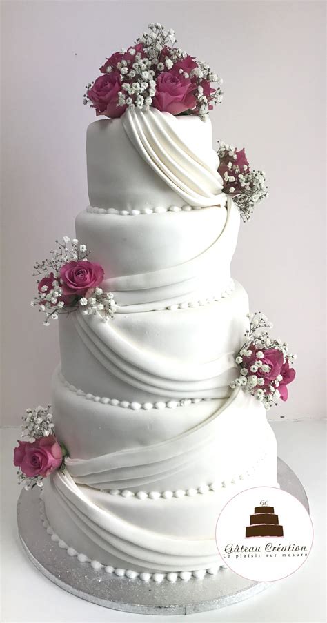 a white wedding cake with pink flowers on top